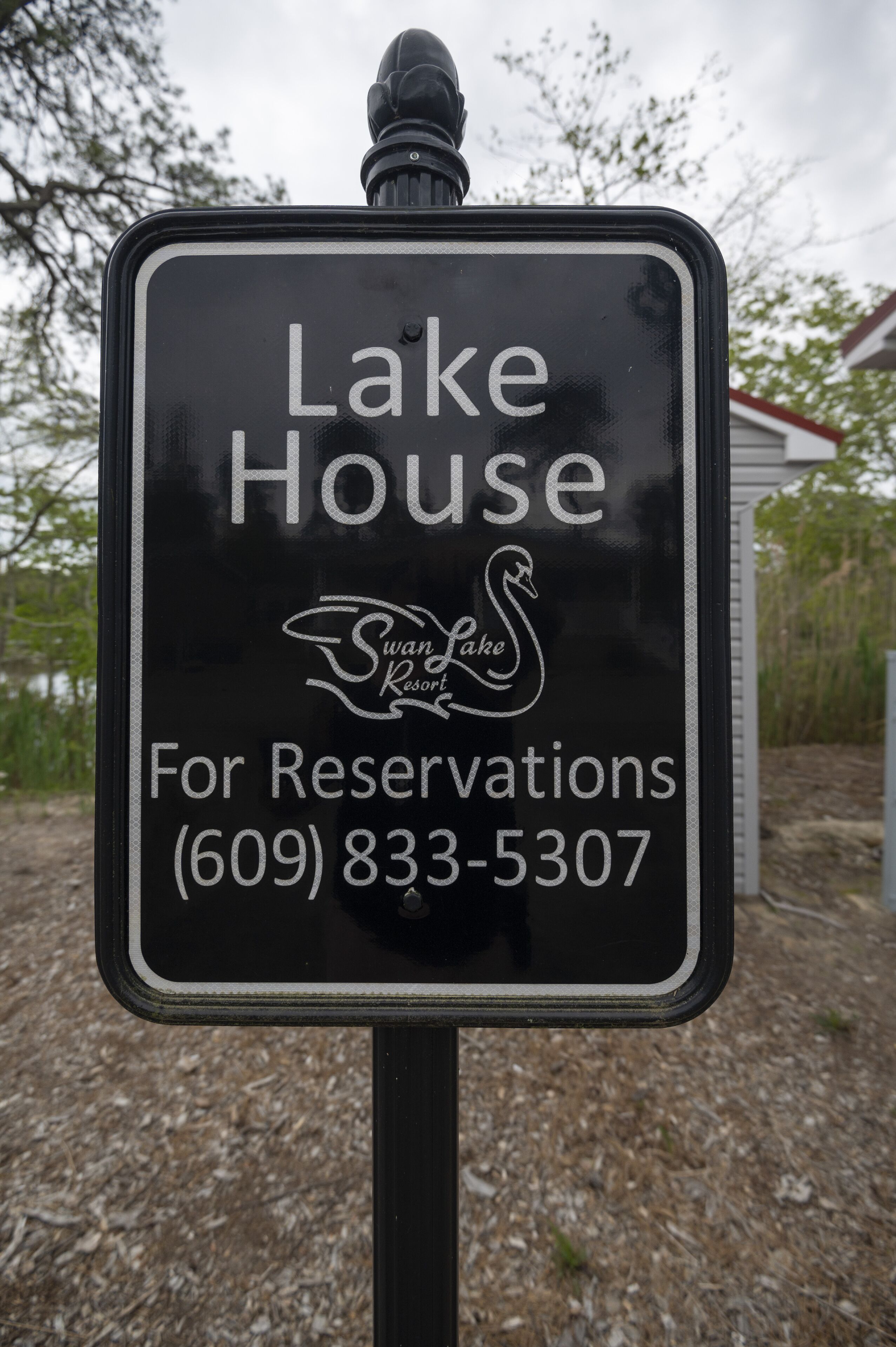 A sign for Lake House at Swan Lake Resort, including a phone number for reservations.