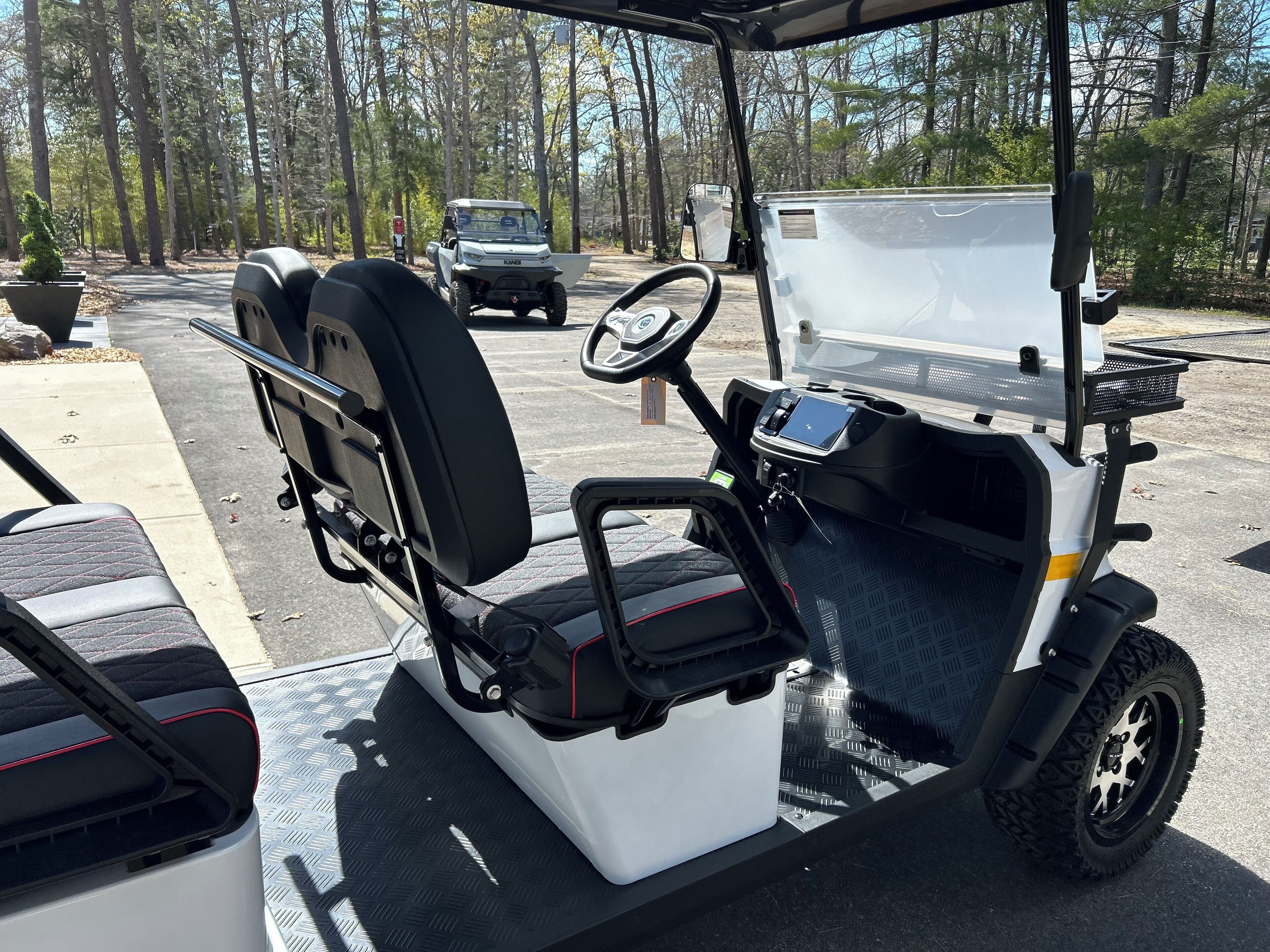 A golf cart with a storage compartment and a steering wheel.