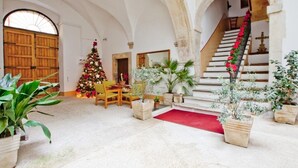 A spacious hall with a wooden staircase, a Christmas tree, and potted plants. - B&B Il Marchese Del Grillo (Sulmona)