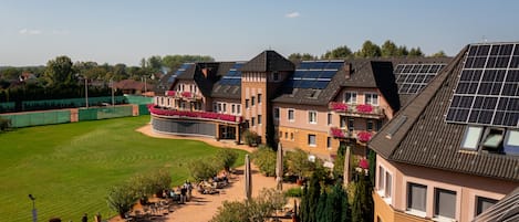 A residential building with multiple balconies, solar panels, and a well-maintained lawn.