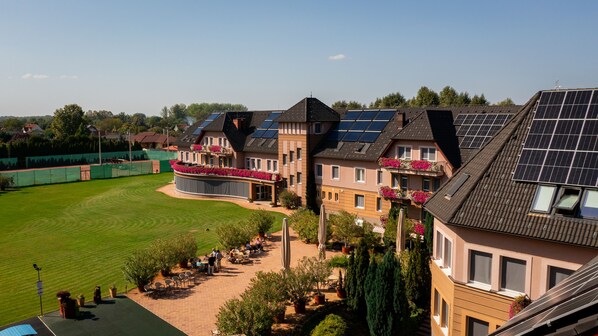 A residential building with multiple balconies, solar panels, and a well-maintained lawn. - Granada Konferencia Wellness Sport Hotel (Kecskemet)