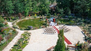 A garden with a pond, seating area, and a small pavilion. - Granada Konferencia Wellness Sport Hotel (Kecskemet)