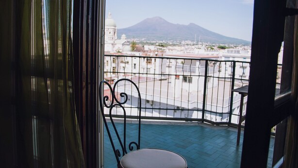 A balcony with a view of a mountain and cityscape. - Piccolo Sogno Inn (Pompei)