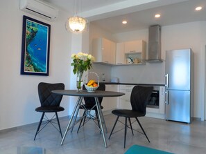 Exclusief appartement, uitzicht op zee | Privékeuken | Een koelkast, een kookplaat, een waterkoker, kookgerei, borden en bestek