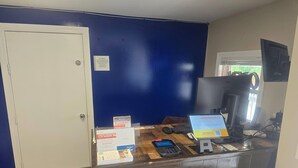 Un mostrador de recepción con una computadora, un monitor y un cartel sobre Choice Privileges.
