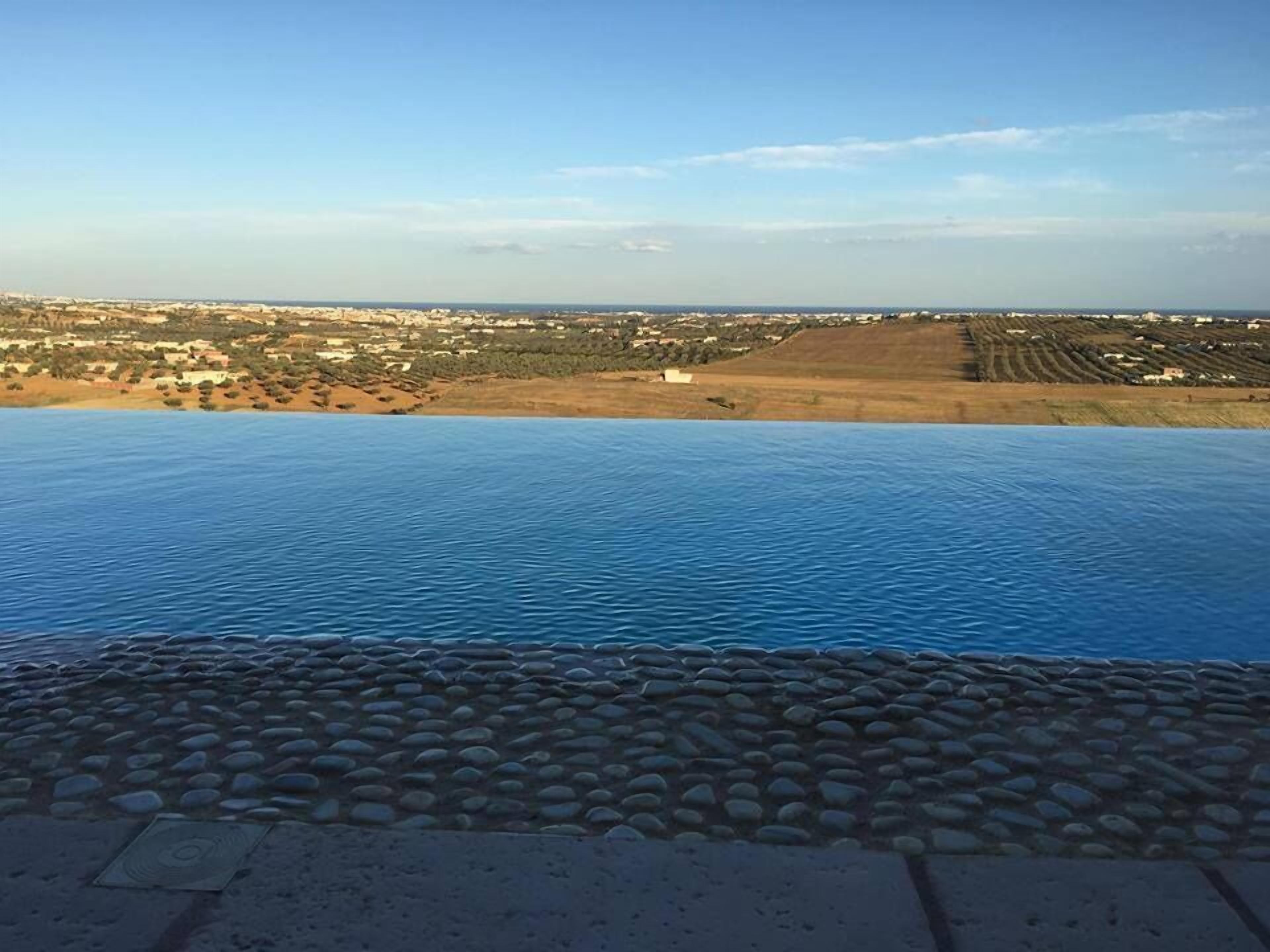Una piscina infinita con vistas a un paisaje costero.