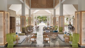 A spacious lobby with high ceilings, a central seating area with sofas and chairs, and a view of the outdoor garden. - Secrets La Romana Resort & Spa  - Adults Only - All Inclusive (San Rafael del Yuma)