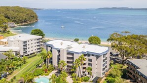 A modern hotel with multiple floors, a swimming pool, and a view of the sea. - Florentine, 7 11 Columbia Close - wifi, air conditioned unit with fantastic views of Little Beach (Nelson Bay)