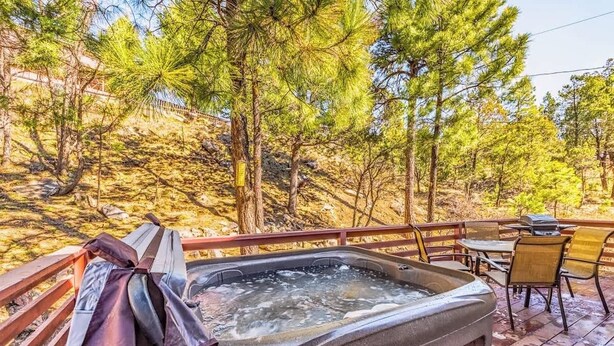 A hot tub on a wooden deck with a view of pine trees. - 3 Bears Cottage | Pet Friendly & Hot tub & Pines! (Ruidoso)
