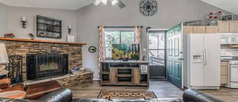 A living room with a fireplace, leather sofa, and a television.