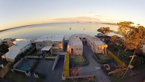 Un barrio residencial con casas modernas, una piscina y vista al mar.