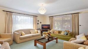 A living room with two sofas, a coffee table, a TV, and curtains.