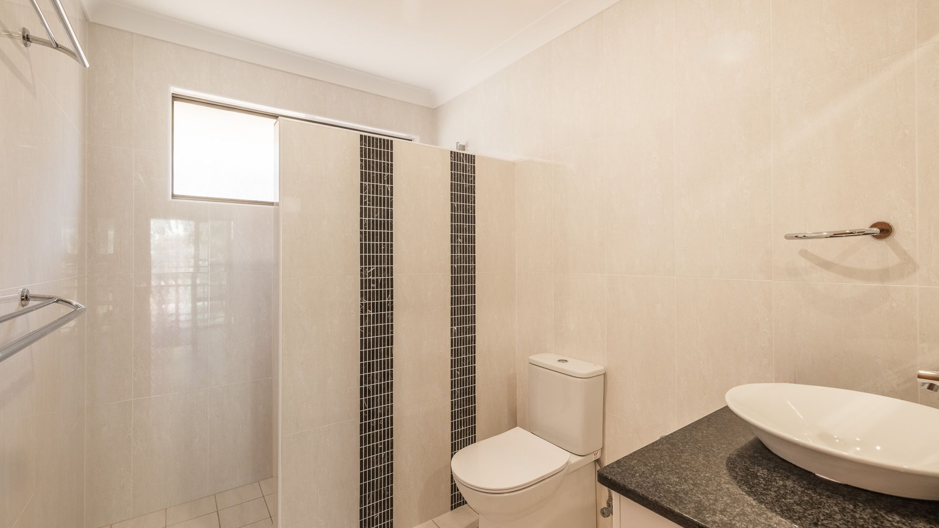 A bathroom with a shower, toilet, and sink.