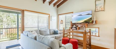 A living room with a sofa, a television, and a wooden coffee table.