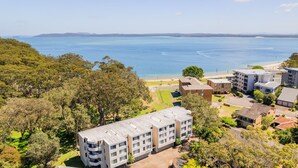 A coastal hotel with multiple buildings, a beach, and a view of the ocean. - Mistral Court, 14/17 Mistral Close - across the road from the beach (Nelson Bay)