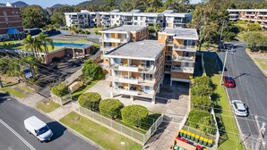 A multi-story residential building with balconies, a swimming pool, and a gated parking area. - Yarramundi, 4,47 Magnus Street - air conditioned unit with air con, wi-fi, water views and close to town (Nelson Bay)