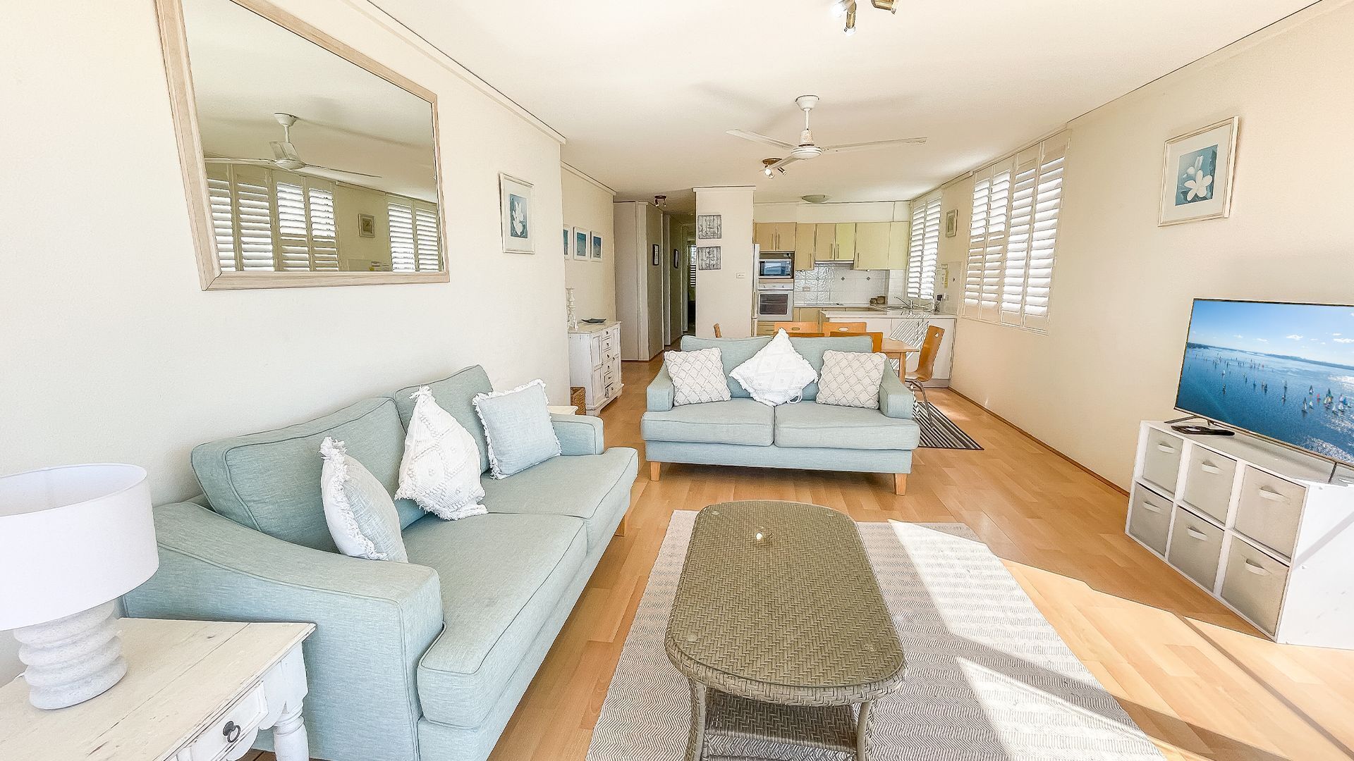 A modern living room with a sofa, a coffee table, and a television.