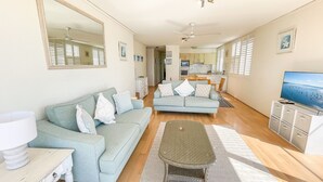 Ein modernes Wohnzimmer mit einer Couch, einem Couchtisch und einem Fernseher.