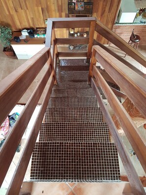 A wooden staircase with a metal safety grid at the bottom, leading to a higher level. - Beautiful country house with swimming pool and panoramic views 1 hour from São Paulo (Extrema)