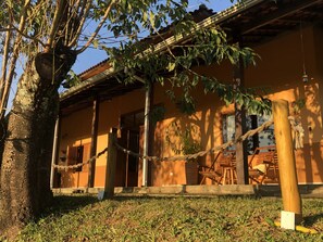 A traditional building with a wooden staircase leading to a covered porch, surrounded by greenery and a rope barrier. - Beautiful country house with swimming pool and panoramic views 1 hour from São Paulo (Extrema)