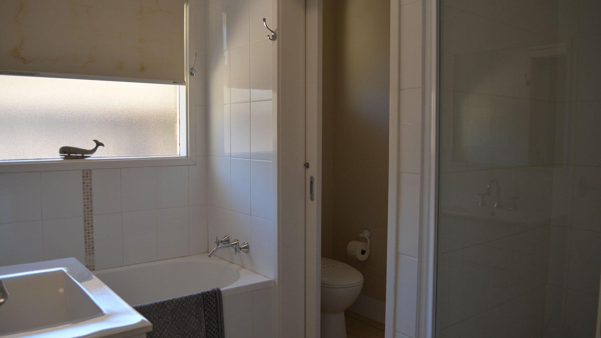 A bathroom with a bathtub, a toilet, and a shower area.