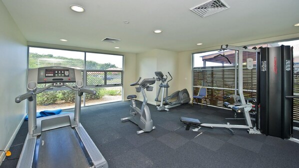 A gym with treadmills, elliptical machines, and weight equipment.