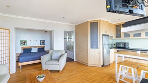 Un appartement moderne comprenant une chambre, un espace de vie, une kitchenette et un coin repas.