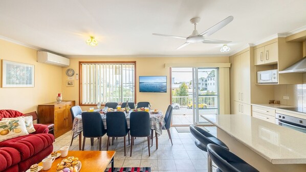 Un appartement moderne comprenant un coin repas, une cuisine et un salon.