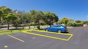 Un parking avec une voiture bleue garée dans un espace délimité.
