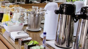 Montaje de bufé con diferentes alimentos, bebidas y una estación de café.