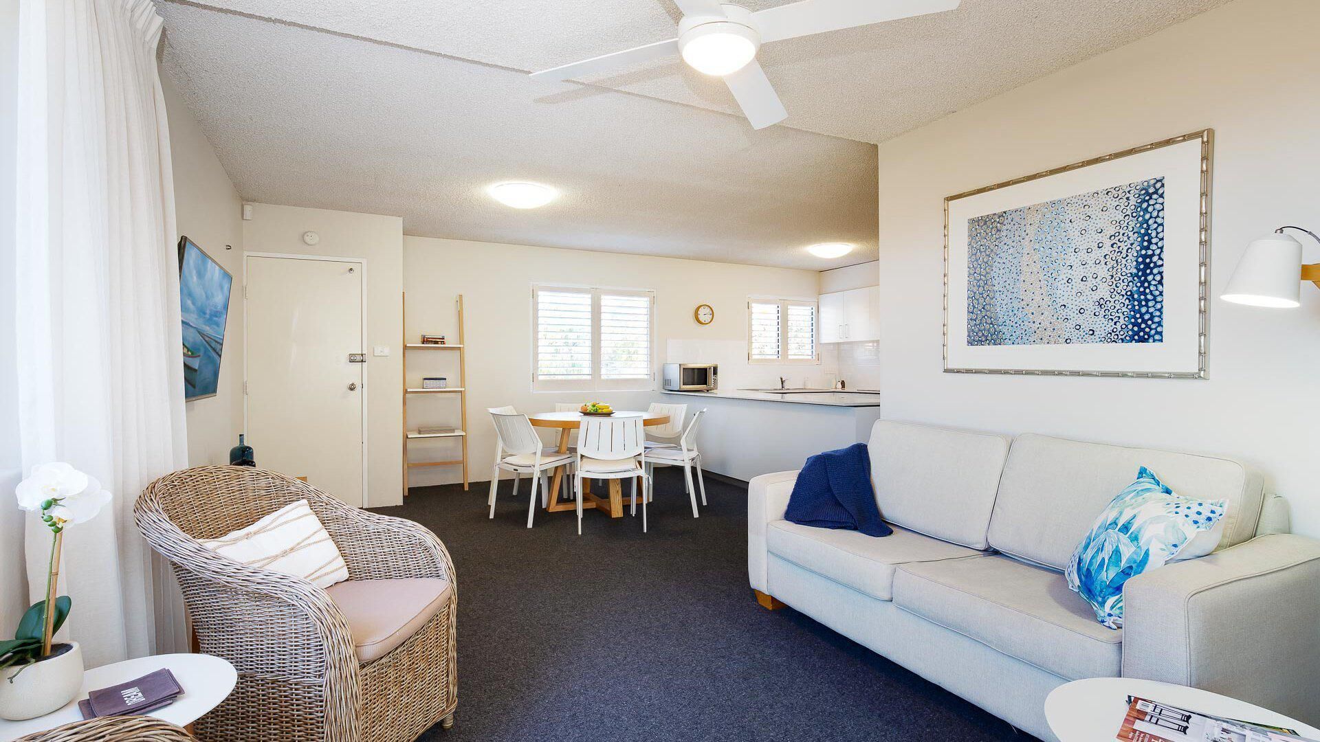 A compact living space with a dining area, kitchenette, and a sofa.