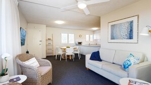 Ein kompakter Wohnraum mit Essbereich, Küchenzeile und Sofa.