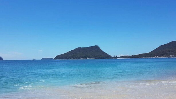 A beach with clear water, distant mountains, and a clear sky. - Sandy Shoal, 46 Rigney Street - Shoal Bay Beach Cottage with aircon (Shoal Bay)