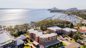 A coastal residential area with a marina, multi-story buildings, and a clear view of the sea.