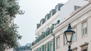 Eine Kopfsteinpflasterstraße gesäumt von historischen Gebäuden, mit Balkonen, Pflasterung und einer Straßenlaterne.