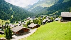 A mountain village with traditional wooden houses, a clear sky, and lush greenery. - Chalet Le Jeuna, Morgins (Morgins)