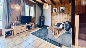 A cozy living room with a wooden ceiling, a fireplace, a television, and a sofa. - Chalet Le Jeuna, Morgins (Morgins)