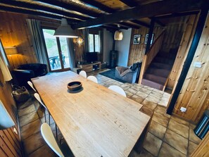 A wooden interior with a large dining table, chairs, and a staircase leading to an upper level. - Chalet Le Jeuna, Morgins (Morgins)