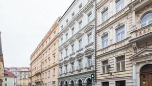 A row of historic buildings with ornate facades, large windows, and a prominent sign for "Pavlů Lazne". - Pretty, comfortable apartment (Praga)