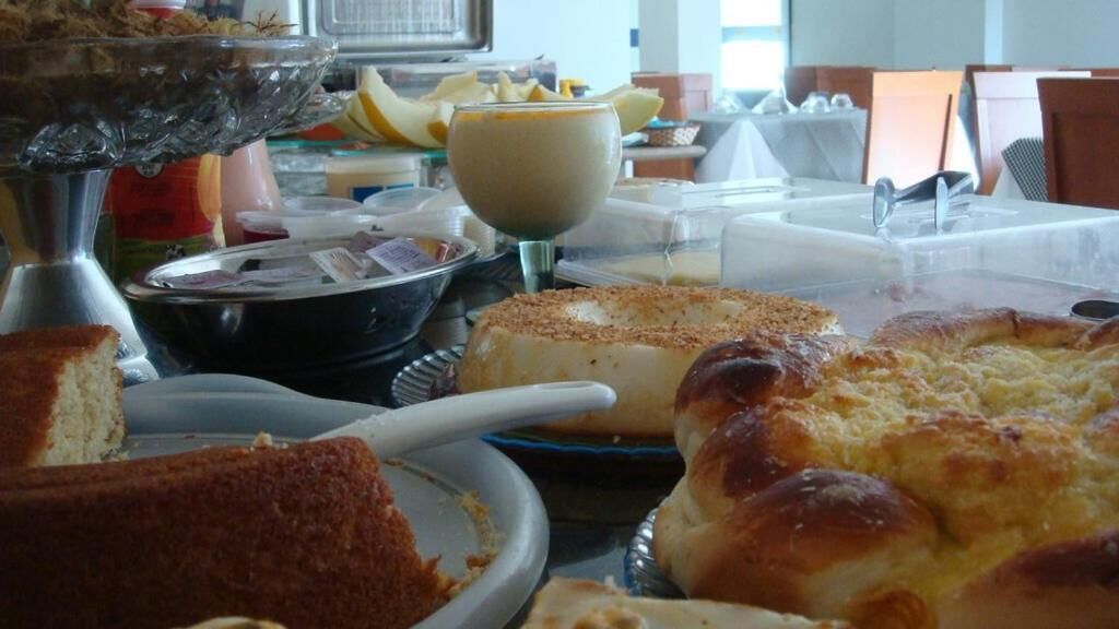 Un bufé con diversos platos, que incluye un pastel grande, un tazón de sopa y un vaso de jugo de naranja.