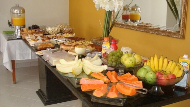 A buffet with various fruits, cheeses, and bread.