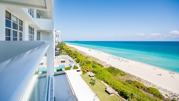 A balcony with a view of a beach and ocean. - Ocean Grand Residences (Miami Beach)