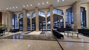 A spacious lobby with large windows, high ceilings, and a modern design. - Ocean Grand Residences (Miami Beach)