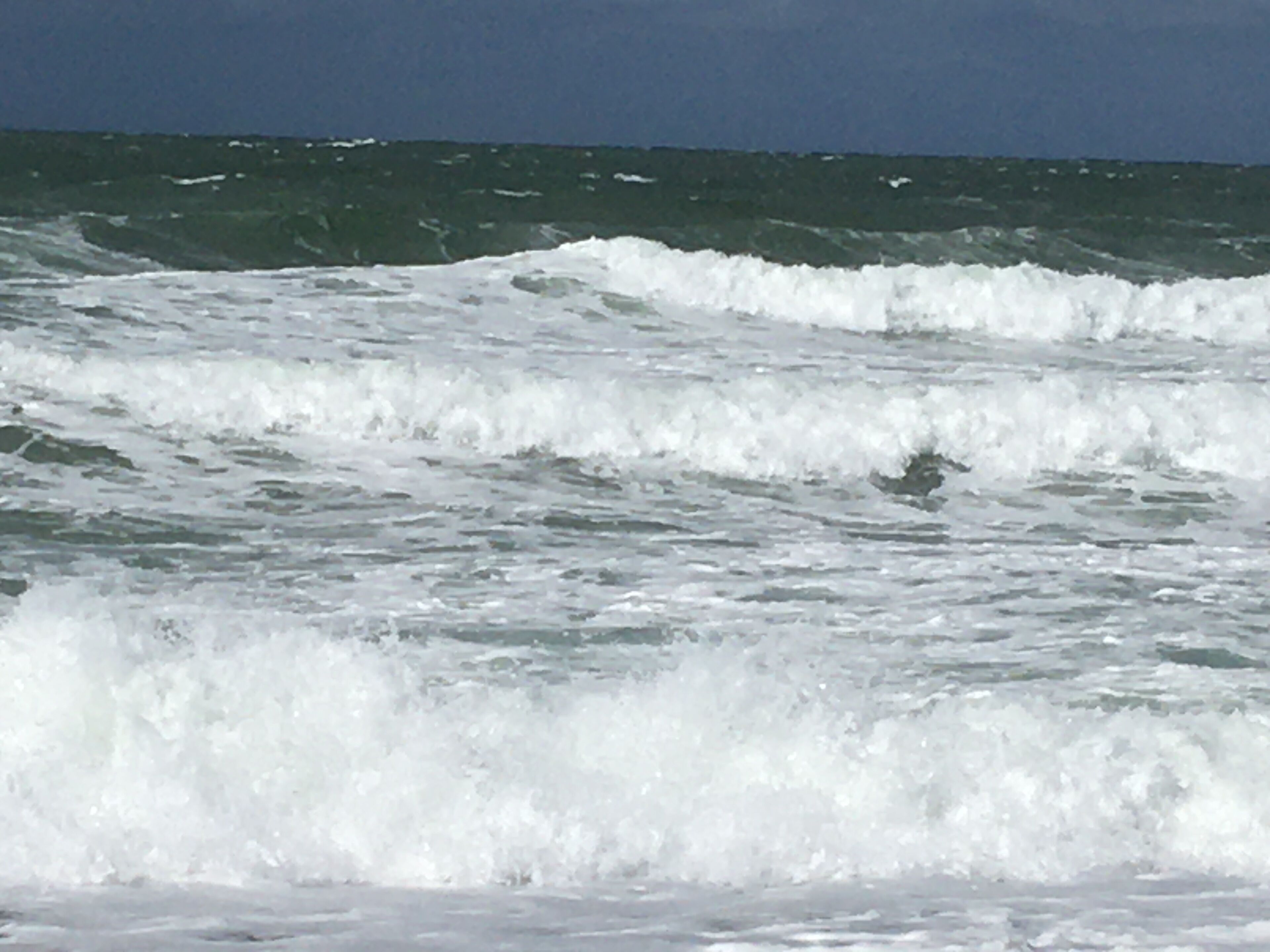 A view of the ocean with waves crashing onto the shore.