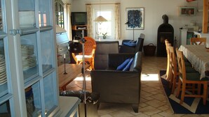 A cozy living room with a fireplace, a dining area, and a kitchen. - Wunderbares Haus nur 20 Meter vom Wasser mit riesengroßes Grundstück! Herrlich. (Dänemark)