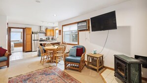 A compact living space with a kitchen, dining area, and a cozy seating area with a fireplace.