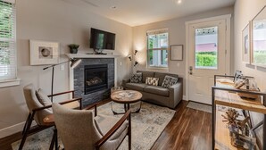 Un salon chaleureux avec une cheminée, des fauteuils confortables et un téléviseur.