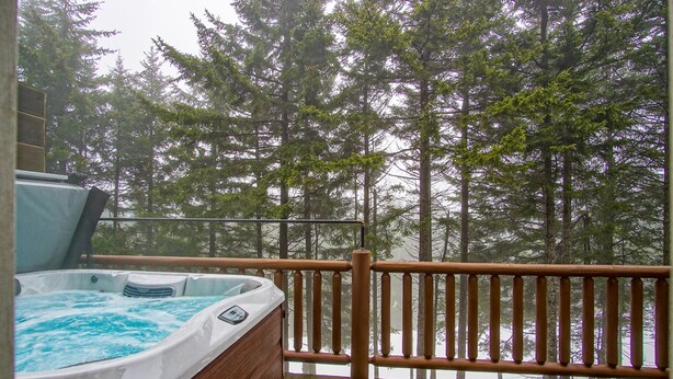 A hot tub on a wooden deck with a view of tall trees. - Loggers Run #7: 5 BR, 3.5 BA: Slope Side. Hot Tub, Overlooks Ski Trail! (Snowshoe)