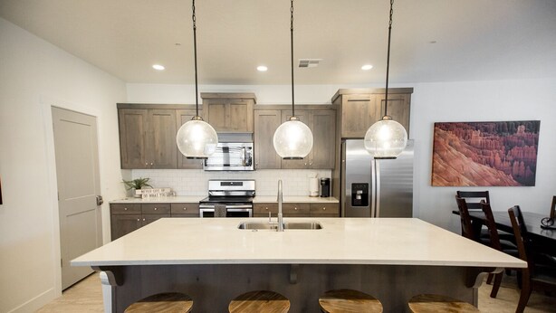 A modern kitchen with a large island, pendant lights, and a dining area with wooden chairs. - ⛏️ Red Rock ⛏️ Adventurous Desert Experience | POOL IS OPEN!!! (Washington)