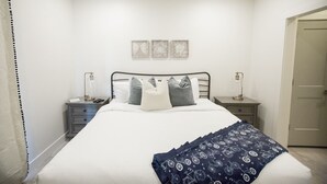 A bedroom with a bed, two bedside tables, a nightstand, a door, and three wall-mounted artworks. - ⛏️ Red Rock ⛏️ Adventurous Desert Experience | POOL IS OPEN!!! (Washington)